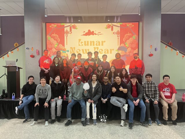 Residents gathered in front of a Lunar New Year backdrop