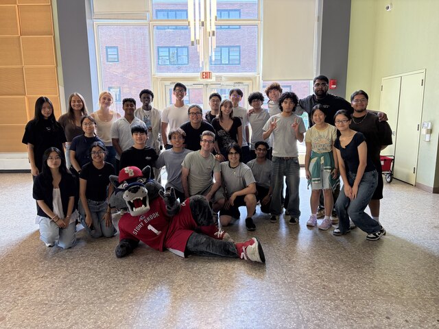 The peer mentoring cohort posing together with the Stony Brook Wolfie mascot